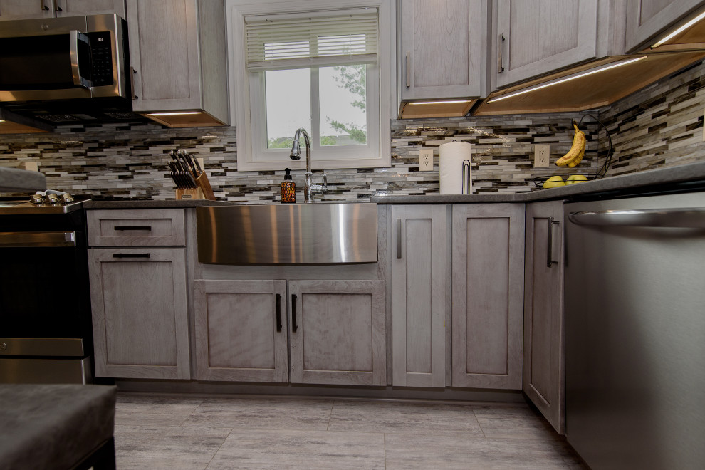 Eat-in kitchen - large transitional u-shaped gray floor eat-in kitchen idea in Baltimore with a farmhouse sink, shaker cabinets, gray cabinets, quartz countertops, multicolored backsplash, glass tile backsplash, stainless steel appliances, an island and gray countertops
