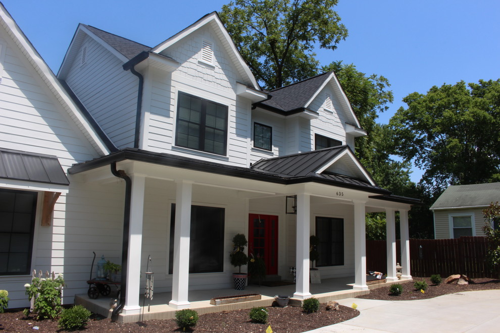 Photo of a large country two-storey white house exterior in St Louis with concrete fiberboard siding, a gable roof and a shingle roof.