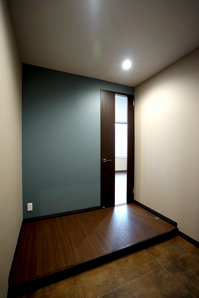 На фото: узкая прихожая среднего размера в стиле модернизм с белыми стенами, коричневым полом, потолком с обоями и обоями на стенах