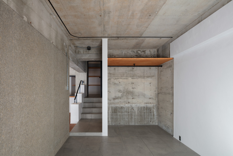 Idée de décoration pour une chambre parentale urbaine de taille moyenne avec sol en béton ciré, un sol gris et poutres apparentes.