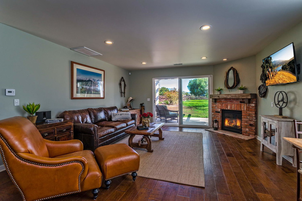 Inspiration for a traditional enclosed living room in San Luis Obispo with blue walls, dark hardwood floors, a standard fireplace and a brick fireplace surround.