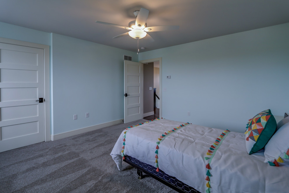 This is an example of a large contemporary guest bedroom in Other with blue walls, carpet and beige floor.