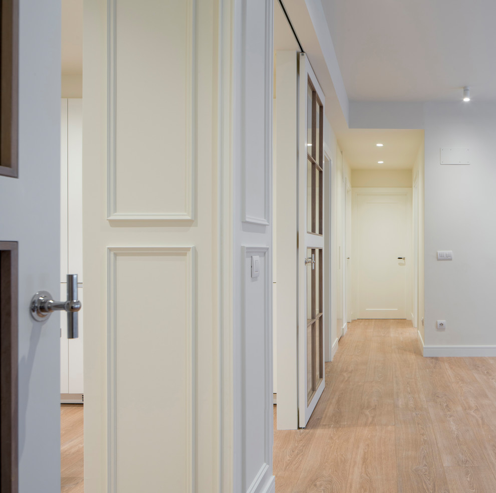 Design ideas for a mid-sized transitional hallway in Bilbao with laminate floors, brown floor and beige walls.