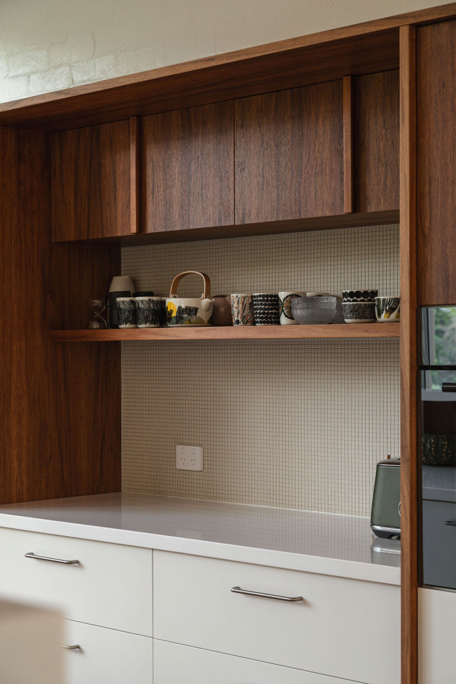 Photo of a mid-sized midcentury galley kitchen in Brisbane with medium wood cabinets, stone tile splashback and with island.