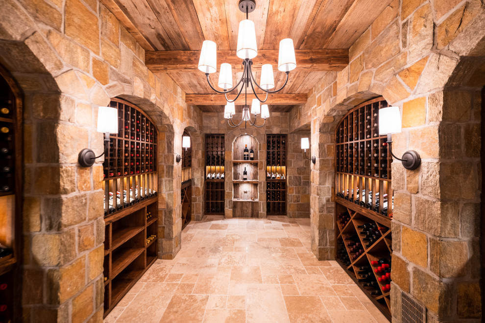 Idée de décoration pour une cave à vin tradition de taille moyenne avec un sol en travertin, des casiers et un sol beige.
