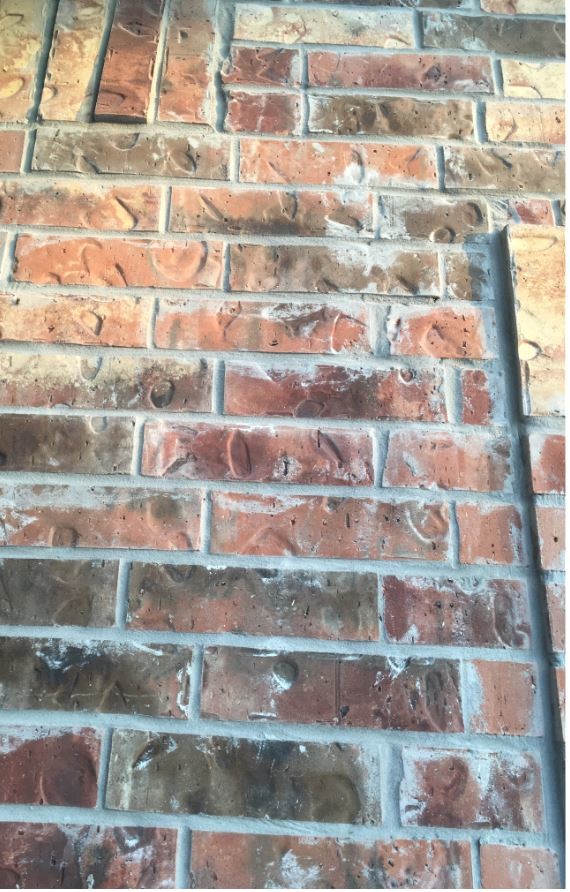 Grey mortar smeared on brick
