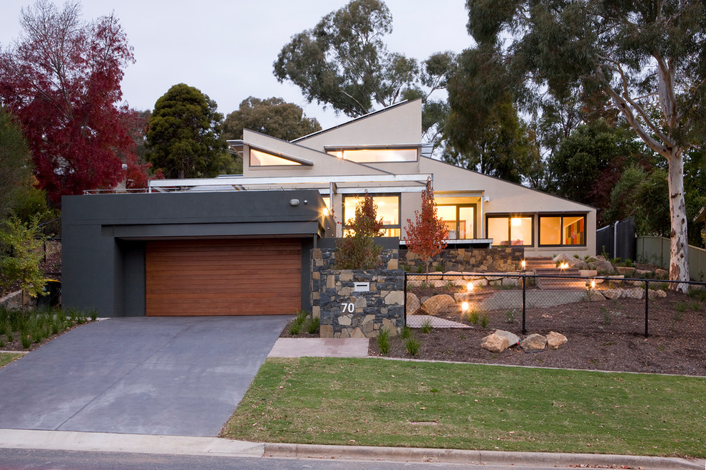 Inspiration for a large contemporary two-storey stucco grey house exterior in Canberra - Queanbeyan with a metal roof.