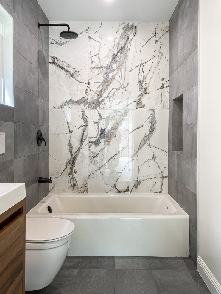 Small trendy master gray tile and porcelain tile porcelain tile, gray floor and single-sink bathroom photo in Los Angeles with flat-panel cabinets, gray cabinets, a wall-mount toilet, gray walls, an integrated sink, quartz countertops, white countertops and a niche