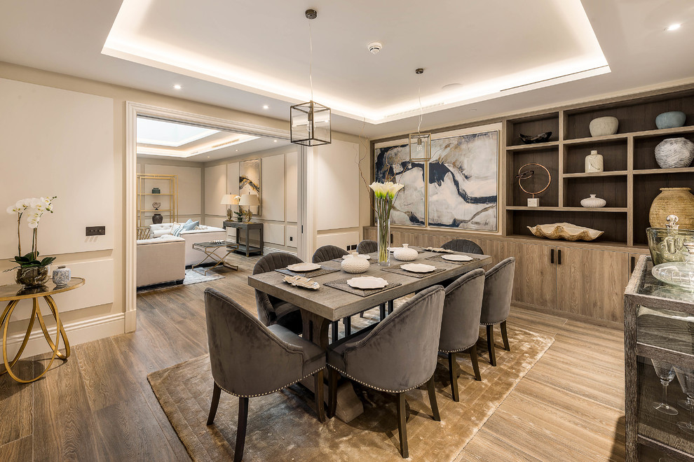 This is an example of a mid-sized transitional separate dining room in London with beige walls, light hardwood floors and brown floor.