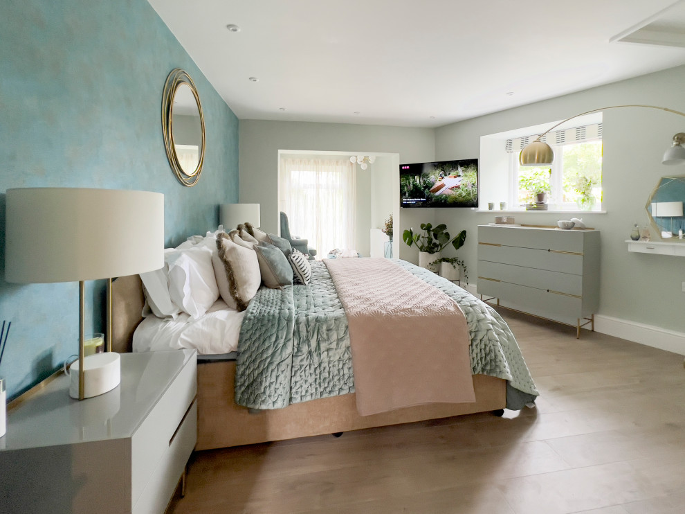 Large rural master bedroom in Gloucestershire with blue walls, vinyl flooring, wallpapered walls and a feature wall.