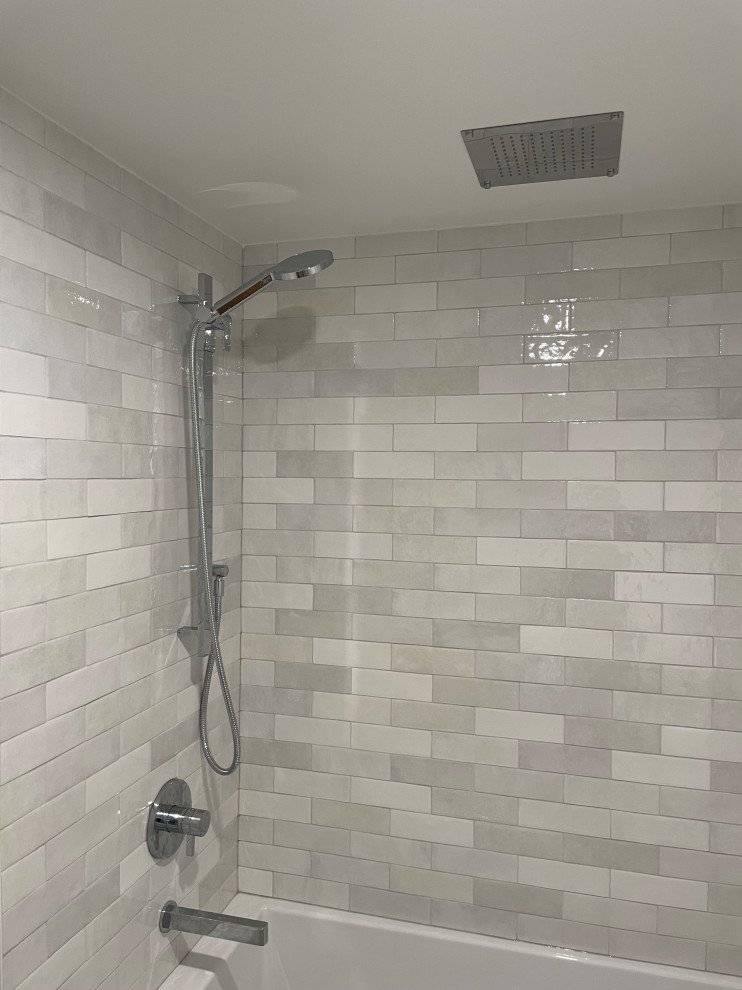 Inredning av ett modernt litet vit vitt badrum med dusch, med släta luckor, skåp i mellenmörkt trä, ett badkar i en alkov, en dusch/badkar-kombination, en toalettstol med hel cisternkåpa, grå kakel, porslinskakel, vita väggar, klinkergolv i porslin, ett undermonterad handfat, bänkskiva i kvartsit, grått golv och dusch med duschdraperi