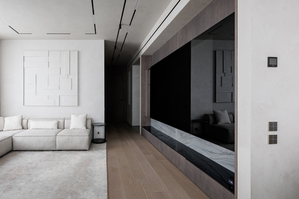 На фото: большая открытая гостиная комната в современном стиле с музыкальной комнатой, серыми стенами, паркетным полом среднего тона и скрытым телевизором с