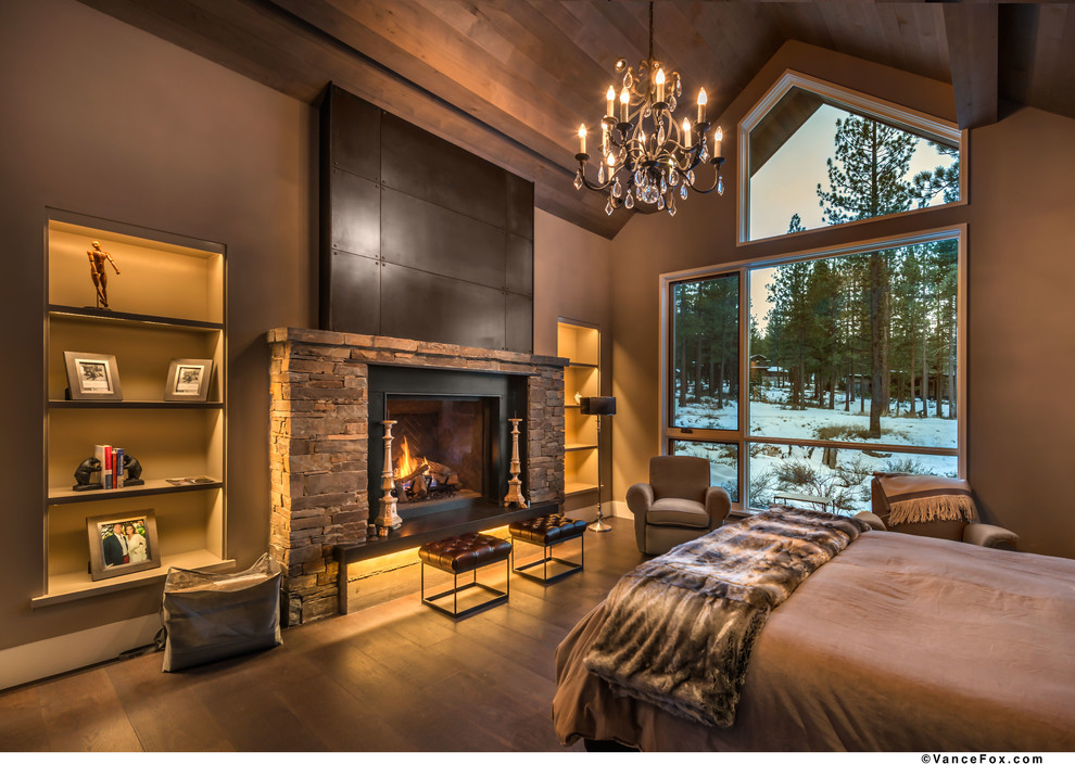 Inspiration for a mid-sized contemporary master bedroom in Sacramento with beige walls, dark hardwood floors, a standard fireplace, a stone fireplace surround and brown floor.