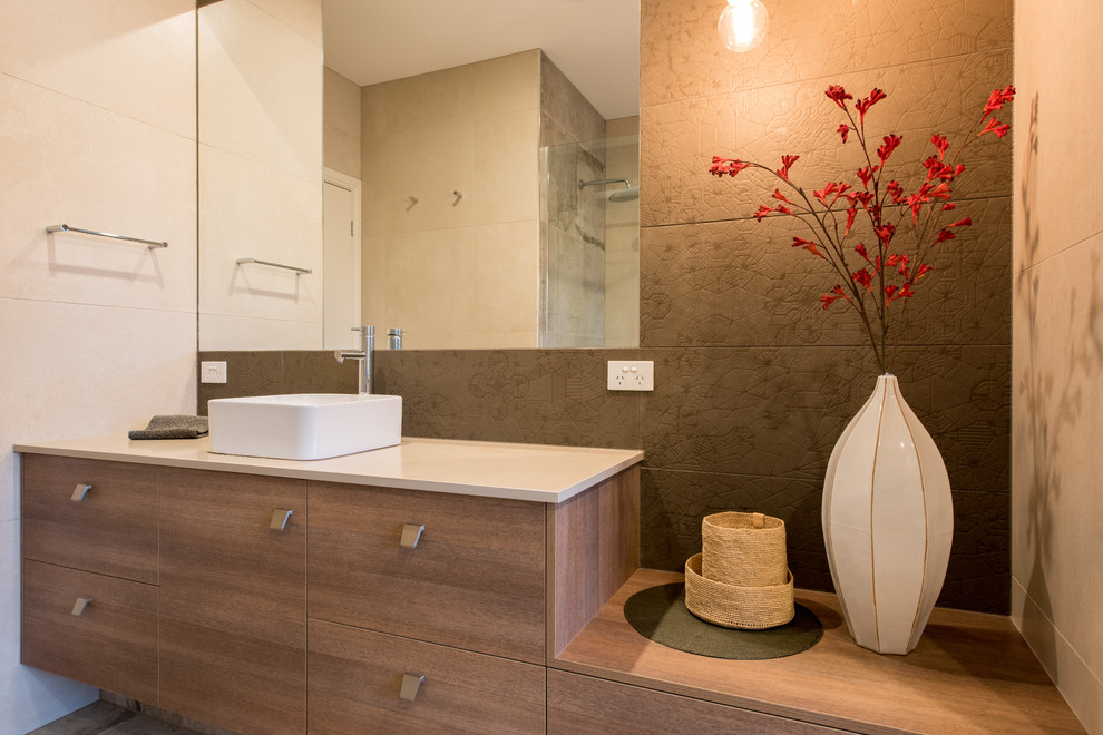 Inspiration for a mid-sized contemporary bathroom in Melbourne with flat-panel cabinets, medium wood cabinets, a drop-in tub, an open shower, multi-coloured tile, porcelain tile, multi-coloured walls, porcelain floors, a vessel sink and engineered quartz benchtops.