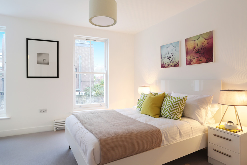 This is an example of a small contemporary guest bedroom in London with white walls, carpet and beige floor.