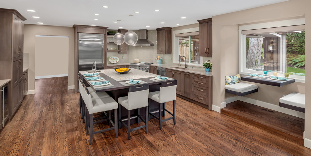 Inspiration for a large transitional u-shaped medium tone wood floor and brown floor eat-in kitchen remodel in Seattle with a single-bowl sink, shaker cabinets, dark wood cabinets, quartzite countertops, gray backsplash, glass tile backsplash, stainless steel appliances, an island and white countertops