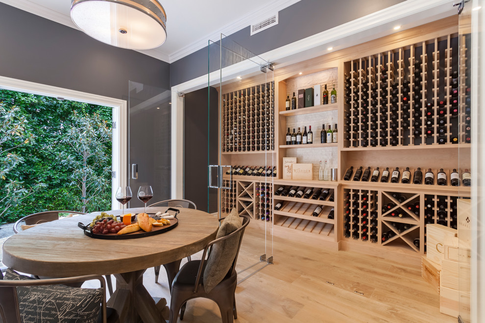 Inspiration for an expansive transitional wine cellar in Los Angeles with light hardwood floors and storage racks.