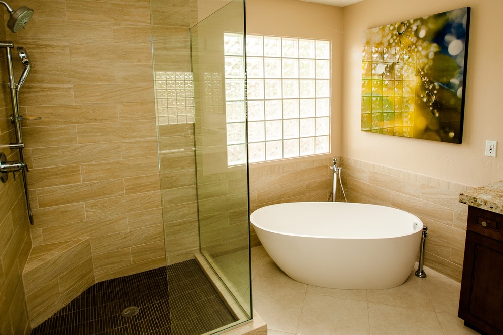 Freestanding bathtub - mid-sized transitional master beige tile and porcelain tile porcelain tile and beige floor freestanding bathtub idea in Phoenix with flat-panel cabinets, medium tone wood cabinets, a two-piece toilet, beige walls, granite countertops and an undermount sink