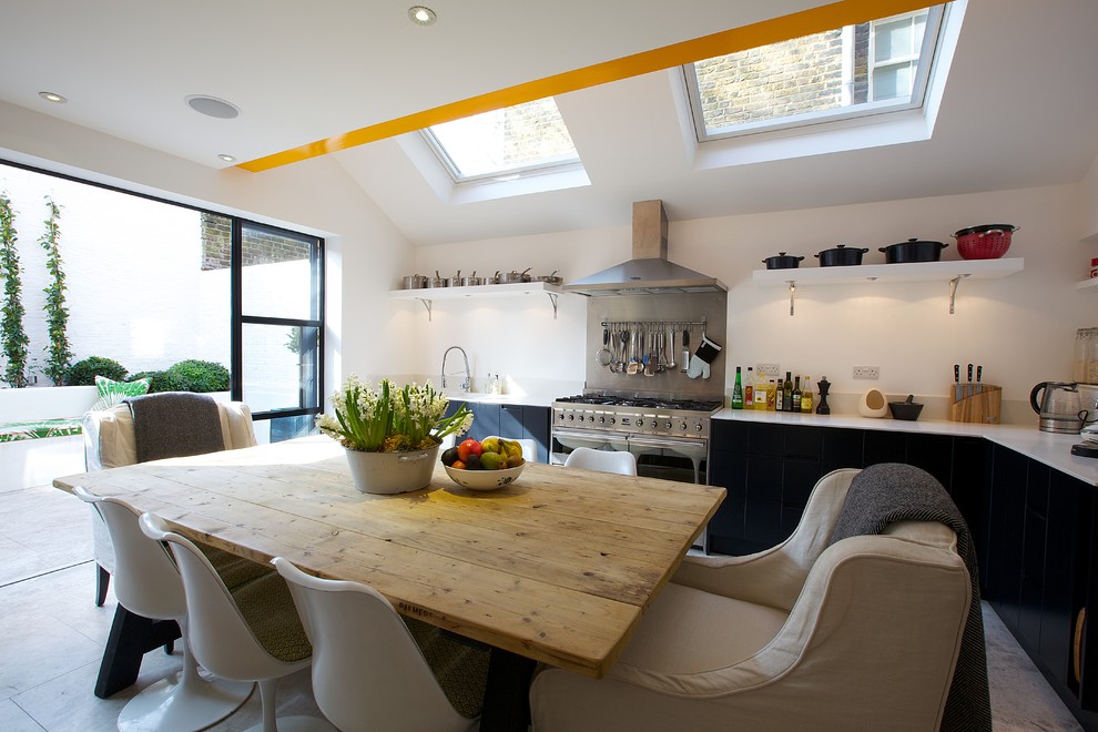 This is an example of a contemporary kitchen in London with white cabinets.