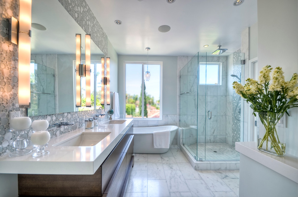 Example of a mid-sized trendy master white tile marble floor freestanding bathtub design in San Diego with an undermount sink, dark wood cabinets, quartz countertops, gray walls and flat-panel cabinets