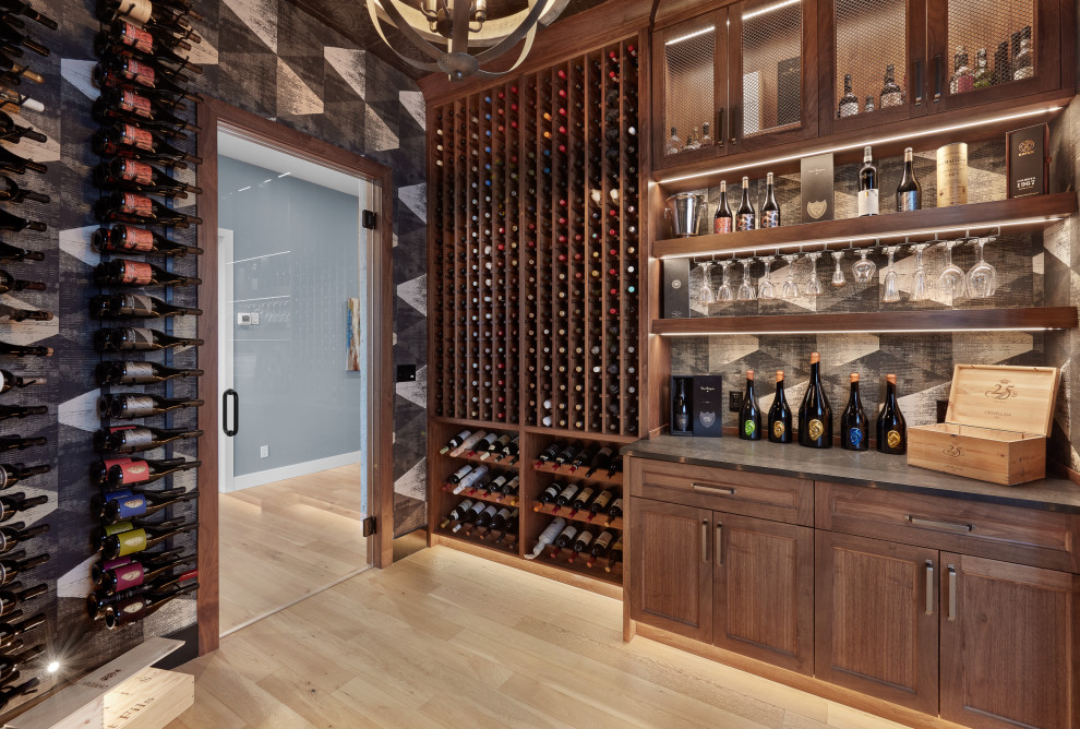 Inspiration for a medium sized urban wine cellar in Edmonton with light hardwood flooring, display racks and beige floors.