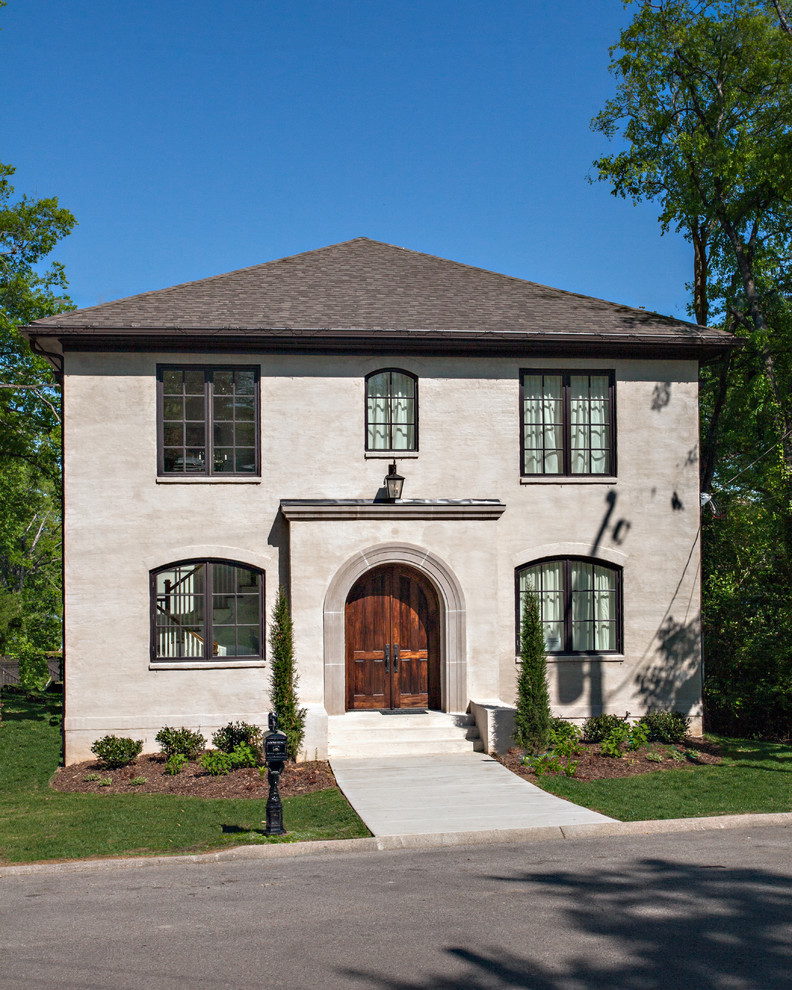 Inspiration for a traditional two-storey beige exterior in Nashville with stone veneer and a hip roof.