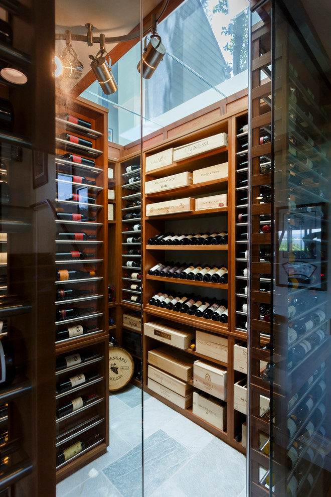 This is an example of a large contemporary wine cellar in New York with marble floors and display racks.