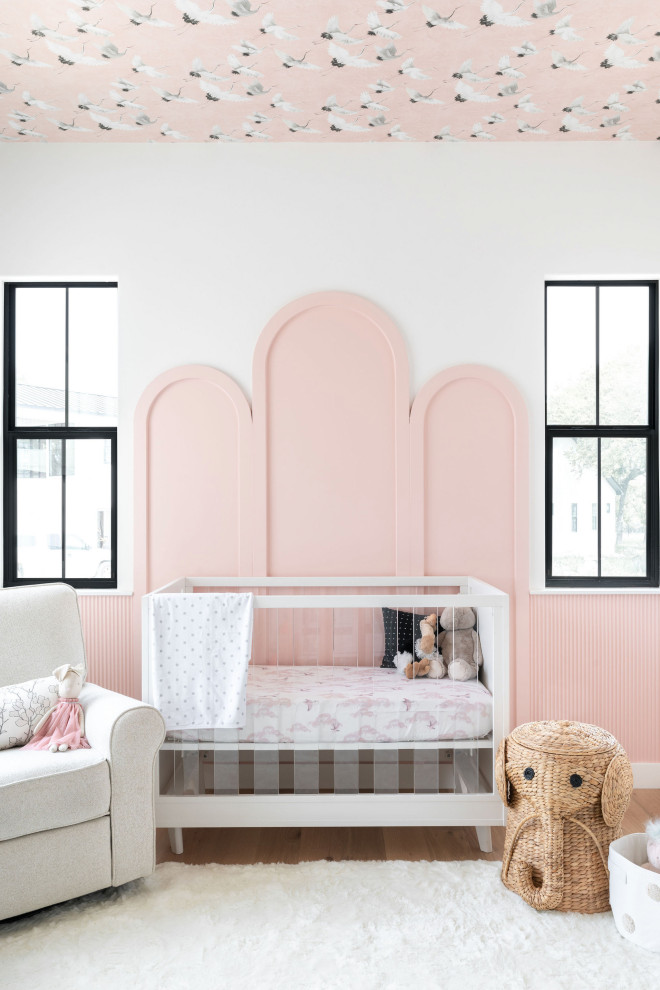 Cette image montre une chambre de bébé fille traditionnelle avec un mur blanc, un sol en bois brun, un sol marron et un plafond en papier peint.