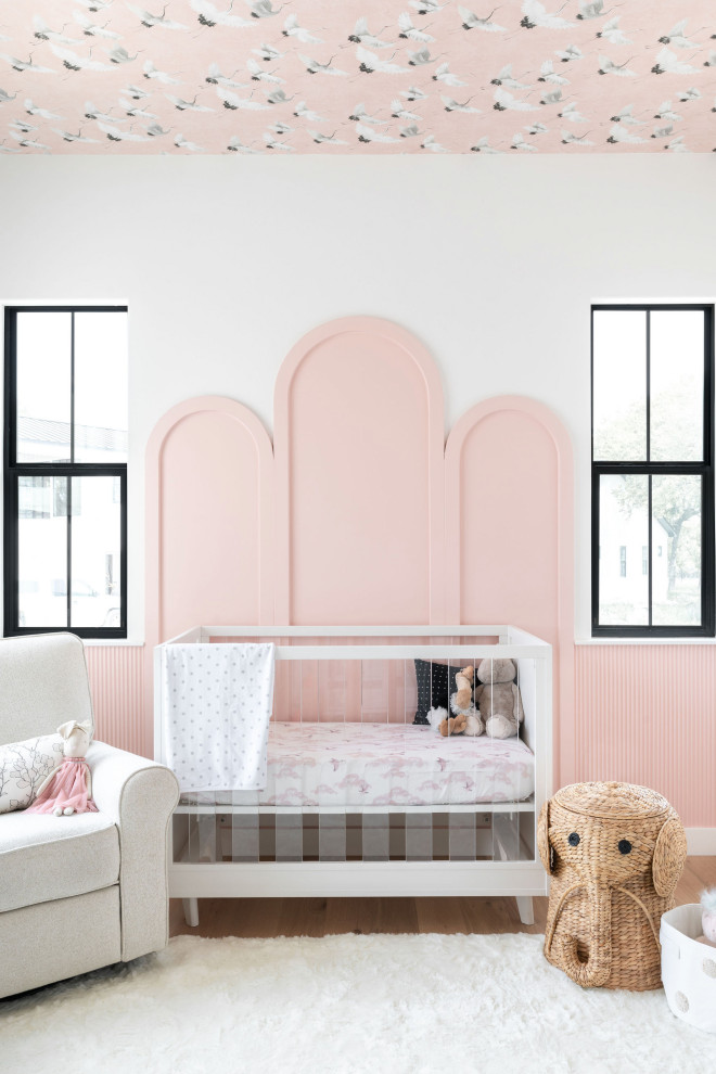 Classic Modern - Example of a transitional girl medium tone wood floor, brown floor and wallpaper ceiling nursery design in Austin with white walls