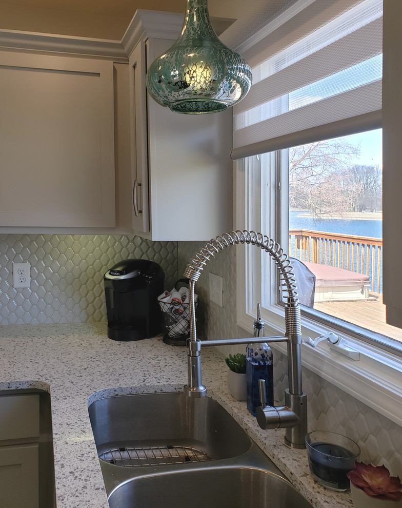 Example of a mid-sized transitional u-shaped ceramic tile and white floor enclosed kitchen design with an undermount sink, shaker cabinets, gray cabinets, quartz countertops, gray backsplash, stainless steel appliances, no island and gray countertops