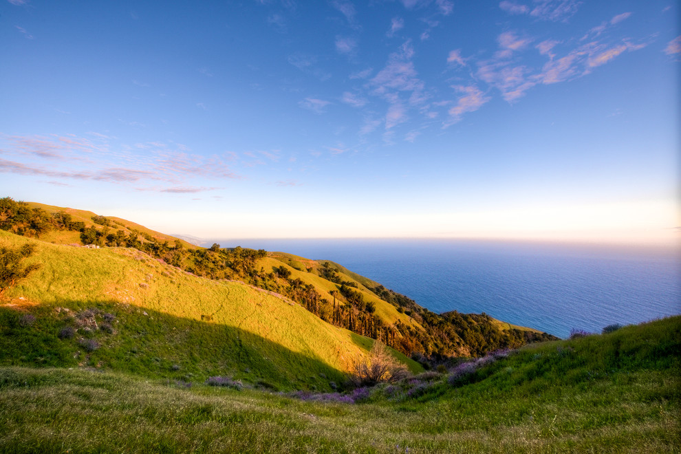 Big Sur Coast Ridge Estate - Breathtaking views of the incomparable Big Sur Coast, this classic Tuscan design of an Italian farmhouse, combined with a modern approach creates an ambiance of relaxed sophistication for this magnificent 95.73-acre, private coastal estate on California’s Coastal Ridge. Five-bedroom, 5.5-bath, 7,030 sq. ft. main house, and 864 sq. ft. caretaker house over 864 sq. ft. of garage and laundry facility. Commanding a ridge above the Pacific Ocean and Post Ranch Inn, this spectacular property has sweeping views of the California coastline and surrounding hills. “It’s as if a contemporary house were overlaid on a Tuscan farm-house ruin,” says decorator Craig Wright who created the interiors. The main residence was designed by renowned architect Mickey Muenning—the architect of Big Sur’s Post Ranch Inn, —who artfully combined the contemporary sensibility and the Tuscan vernacular, featuring vaulted ceilings, stained concrete floors, reclaimed Tuscan wood beams, antique Italian roof tiles and a stone tower. Beautifully designed for indoor/outdoor living; the grounds offer a plethora of comfortable and inviting places to lounge and enjoy the stunning views. No expense was spared in the construction of this exquisite estate.