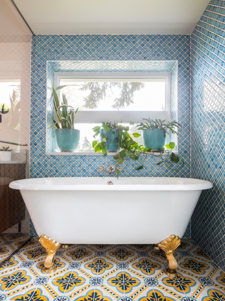 На фото: большая главная ванная комната в современном стиле с фасадами в стиле шейкер, фасадами цвета дерева среднего тона, ванной на ножках, душевой комнатой, унитазом-моноблоком, синей плиткой, керамогранитной плиткой, белыми стенами, полом из цементной плитки, врезной раковиной, столешницей из кварцита, разноцветным полом, душем с распашными дверями, белой столешницей, нишей, тумбой под две раковины и встроенной тумбой