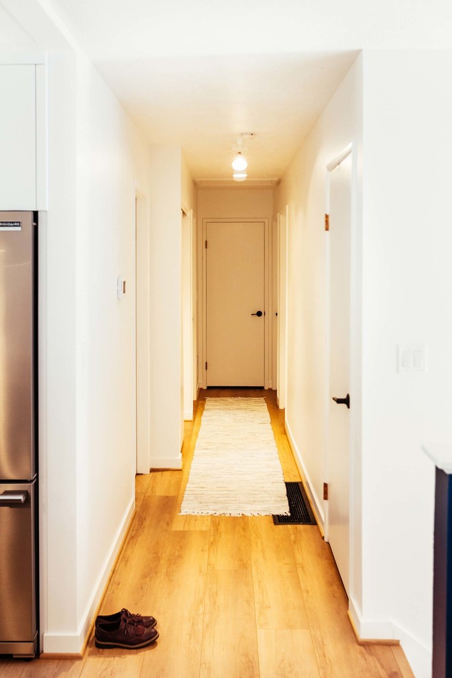 This is an example of a mid-sized contemporary hallway in Portland with vinyl floors and brown floor.