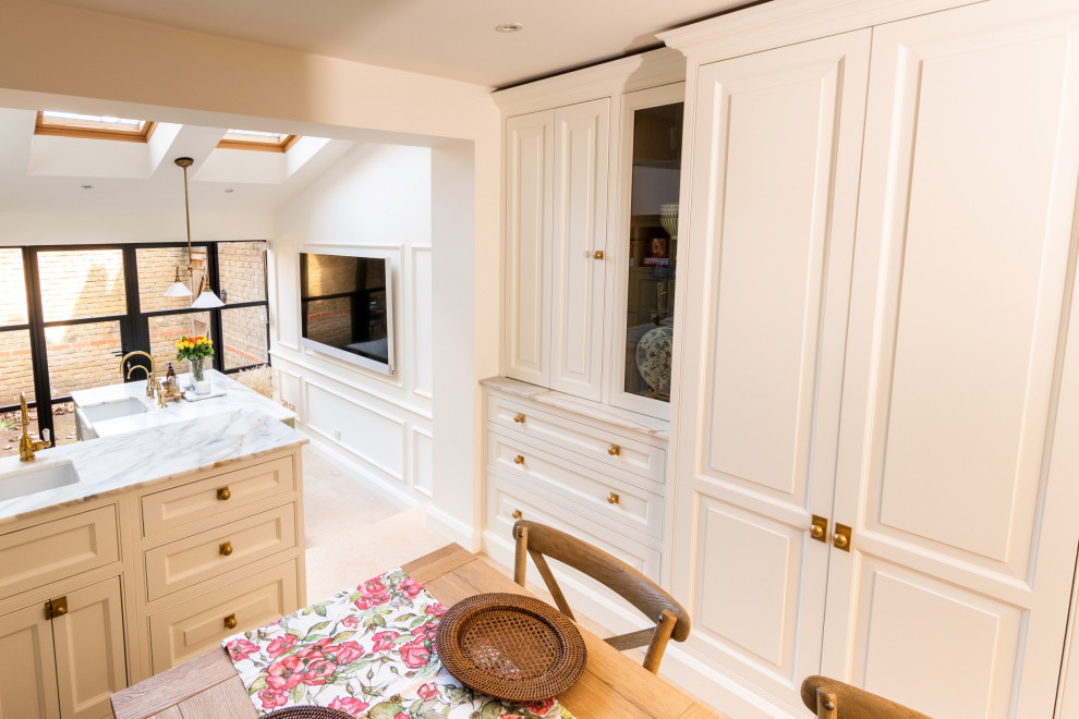 Inspiration for a large traditional galley open plan kitchen in London with a belfast sink, quartz worktops, grey splashback, stainless steel appliances, ceramic flooring, an island, beige floors, grey worktops, a vaulted ceiling and a feature wall.