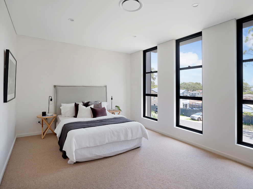 This is an example of a transitional bedroom in Sydney with white walls, carpet and beige floor.