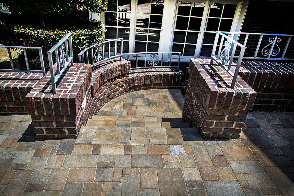 Large contemporary front yard patio in Orange County with brick pavers.