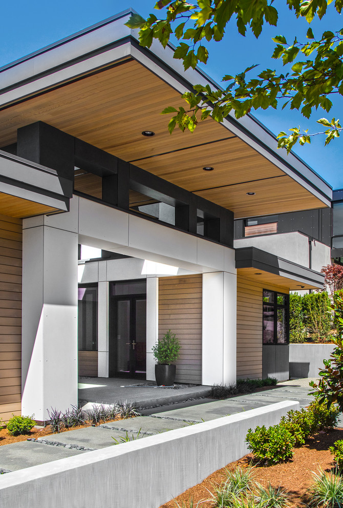 This is an example of a large contemporary two-storey multi-coloured house exterior in Seattle with mixed siding, a flat roof and a metal roof.
