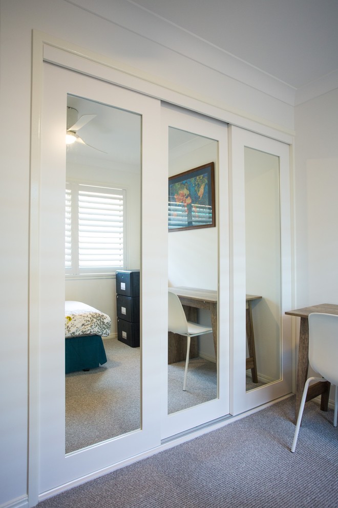 This is an example of a small traditional guest bedroom in Brisbane with white walls, carpet and grey floor.