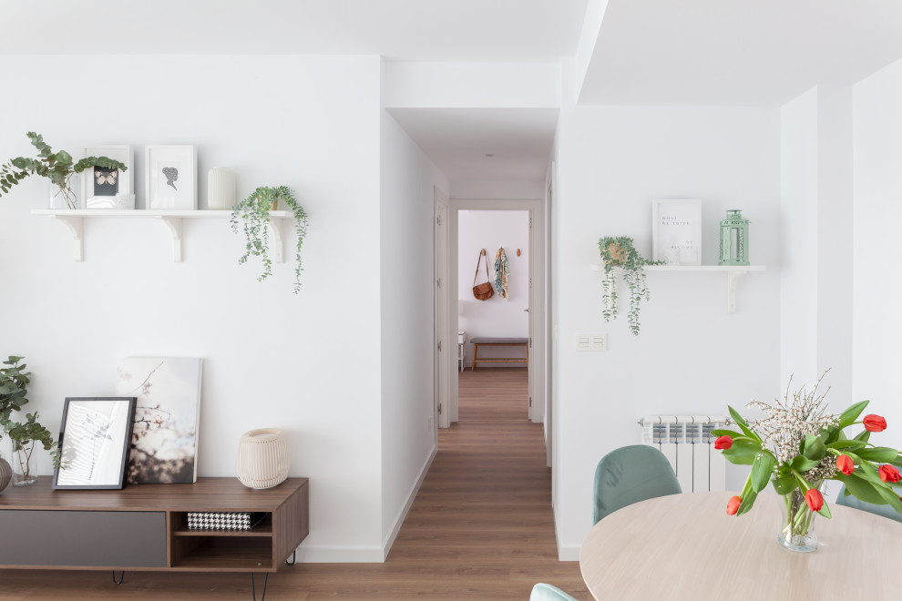 Inspiration for a mid-sized scandinavian basement in Madrid with white walls, medium hardwood floors and brown floor.