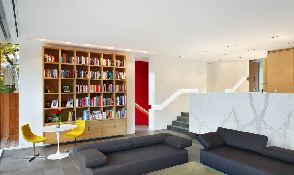 Contemporary family room in Toronto with a library and white walls.