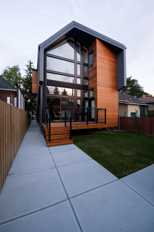 Design ideas for a modern two-storey grey house exterior in Calgary with metal siding and a metal roof.