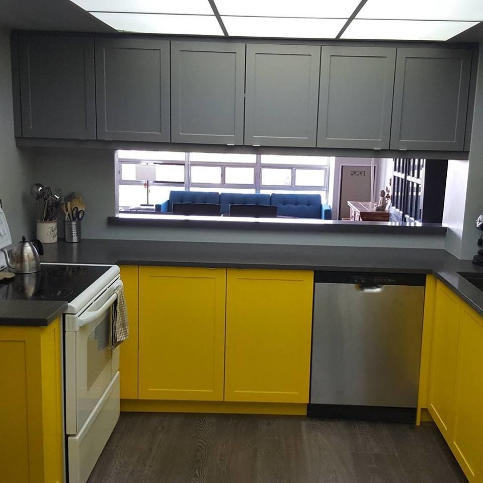 Photo of a small contemporary u-shaped eat-in kitchen in Toronto with an undermount sink, shaker cabinets, yellow cabinets, quartz benchtops, white appliances, laminate floors, grey floor and grey benchtop.