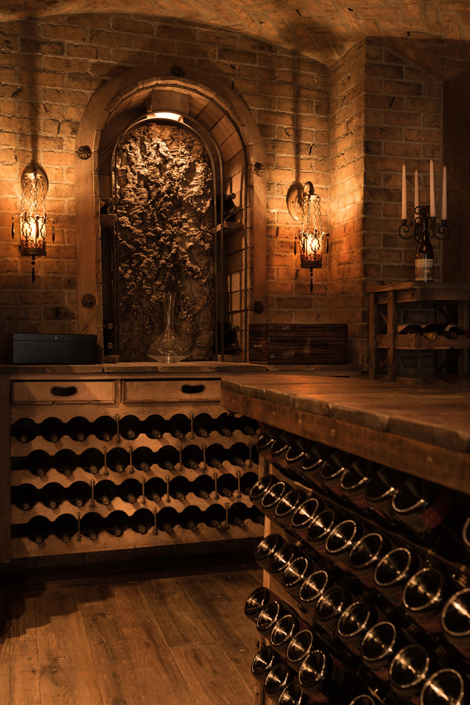 Inspiration for a mediterranean wine cellar in Orange County with dark hardwood floors and storage racks.