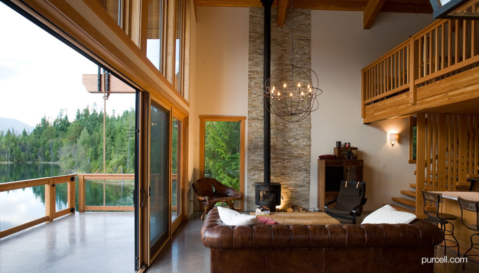 Photo of a contemporary formal open concept living room in Vancouver with white walls, concrete floors, a wood stove, a stone fireplace surround and no tv.