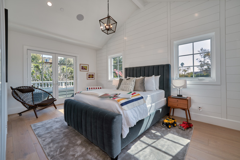 Photo of a large contemporary guest bedroom in Los Angeles with white walls, medium hardwood floors, brown floor, planked wall panelling and vaulted.