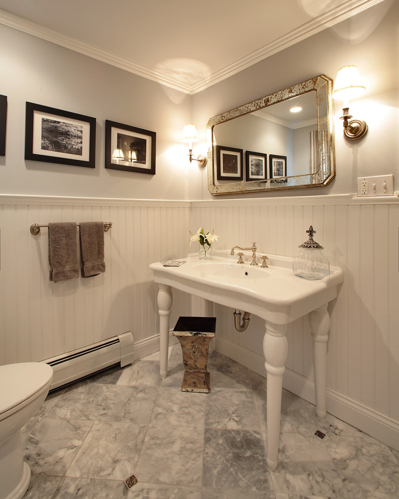 This is an example of a traditional powder room in Other with a console sink.