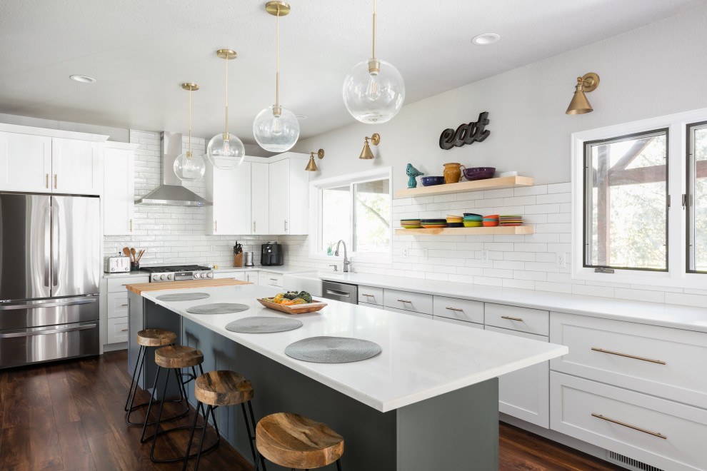 Example of a large transitional u-shaped dark wood floor eat-in kitchen design in Denver with a farmhouse sink, shaker cabinets, white cabinets, quartz countertops, white backsplash, porcelain backsplash, stainless steel appliances, an island and white countertops