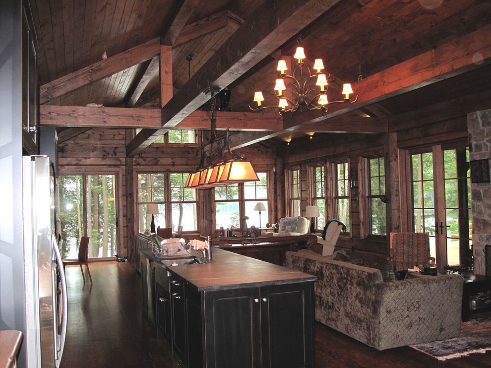 Eat-in kitchen - mid-sized rustic galley dark wood floor eat-in kitchen idea in Toronto with a farmhouse sink, shaker cabinets, black cabinets, soapstone countertops, black backsplash, stainless steel appliances and an island