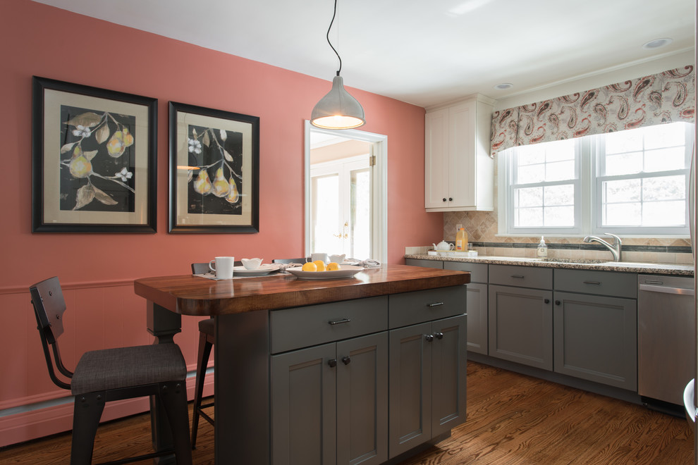 Example of a mid-sized transitional l-shaped medium tone wood floor eat-in kitchen design in Philadelphia with shaker cabinets, gray cabinets, granite countertops, beige backsplash, travertine backsplash, stainless steel appliances, an island and an undermount sink