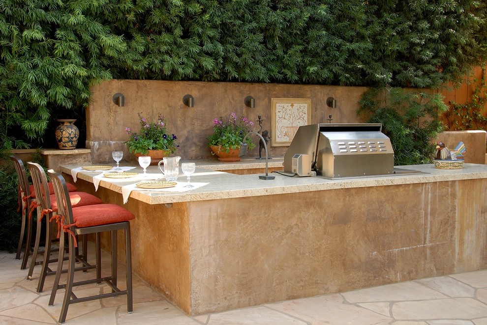 Design ideas for a large mediterranean backyard patio in Los Angeles with natural stone pavers.
